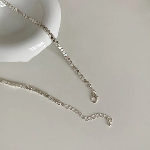 Détail du collier à perles hexagonales argentées avec fermoir mousqueton et chaîne d'extension