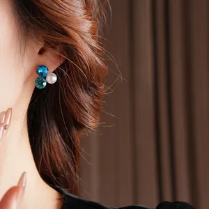 Elegant silver earrings featuring crystal clusters and white pearls on female model