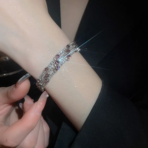 Detailed view of silver three-layer wrap bracelet with purple and white cubic zirconia