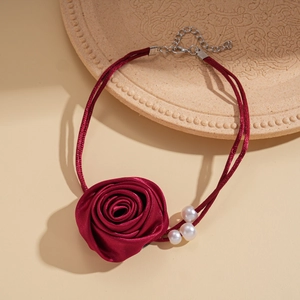 Detail of burgundy satin rose choker with white pearl accents and silver extension chain
