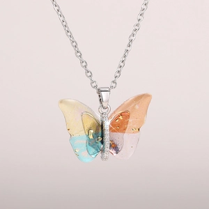 Close-up of a dreamy acrylic butterfly pendant with gold foil and colorful gradients