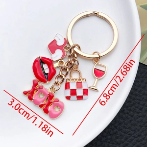 Detailed view of XOXO gold keychain with red heart bag and lip charms showing dimensions