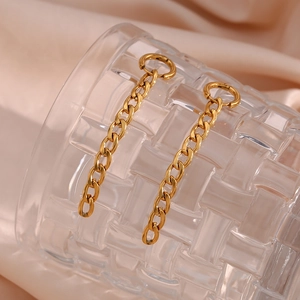 Boucles d'oreilles pendantes Figaro dorées sur bord de verre et fond en soie champagne
