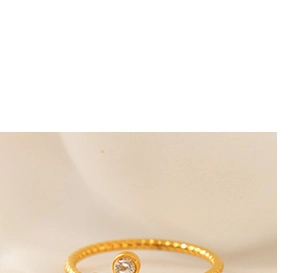 Macro shot of 18K gold plated rope twist ring with round cubic zirconia bezel setting
