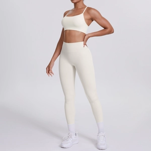 Detail eines cremefarbenen Yoga-Sets mit Cross-Back-BH und hoch taillierter Leggings