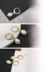 Detail view of baroque freshwater pearl earrings with 18K gold plated clasp and ruler scale