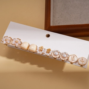 Detailed set of retro floral earrings with pearls and rhinestones on a display card