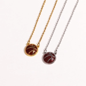 Detail showing gold and silver basketball pendant necklaces with red enamel on white background