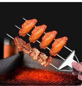 Three-prong stainless steel BBQ skewer with sliding handle holding grilled chicken wings