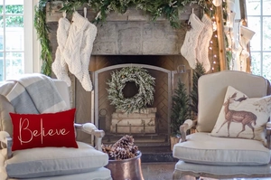 Cozy Christmas scene featuring a red Lumbar pillow with white Believe text on armchair
