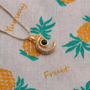 Collier plaqué or avec pendentif croissant de lune, zircons et détail mauvais œil
