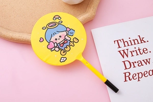 Detail of yellow fan-shaped ballpoint pen featuring a cute cartoon girl and CUTE text