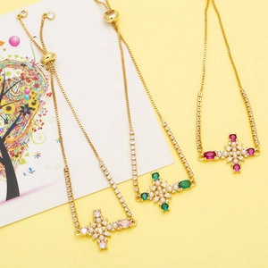 Detailed view of adjustable gold bracelets with cross charms and colorful zircons