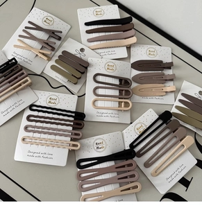 Flat lay of earth-toned matte hair clips in geometric shapes on display cards