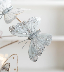 Close-up of mesh butterfly ornament with silver glitter and faux pearls on clip