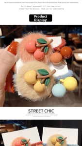 Dettaglio di elastici per capelli in peluche con ciondoli a ciliegia su cartoncino