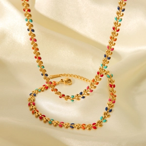 Golden stainless steel necklace featuring colorful enamel olive leaf charms on silk