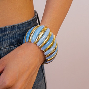 Close-up of a wide elastic bracelet with blue resin and golden metal segments