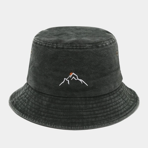 Close-up of mountain sunset embroidery and breathable metal eyelets on washed denim bucket hat