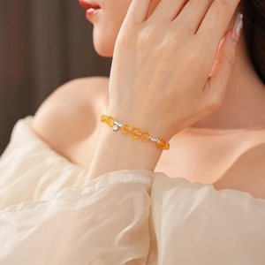 Close-up of citrine beaded bracelet with silver accents worn on a woman's wrist
