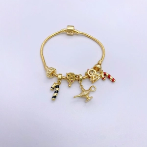 Golden charm bracelet with Christmas tree, Ferris wheel, and magic lamp pendants on white background
