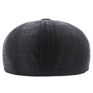 Close-up of the grey plaid texture and neat stitching on the back of a retro newsboy hat