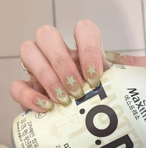 Close-up of green gradient cat eye press-on nails with white star designs and square shape