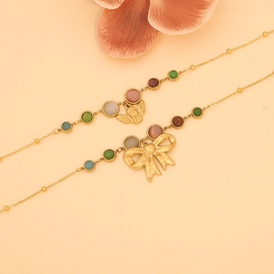 Vintage cat eye bead necklaces with gold angel and bow pendants on soft pink background