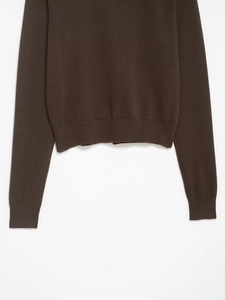 Detail of dark brown knit cardigan showing ribbed hem and fine wool texture