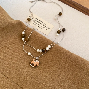 Détail du collier double rang avec perles oeil de tigre et pendentif cheval en bois