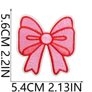 Detailed view of pink embroidered bow patch with red edges and size dimensions in inches