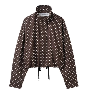 Detailed view of the brown polka dot hooded jacket featuring a drawstring hem and zip closure