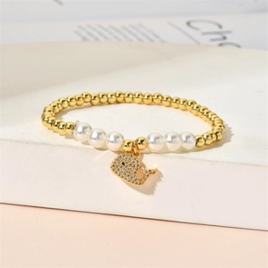 Macro detail of beaded bracelet with pearl accents and a sparkling whale charm