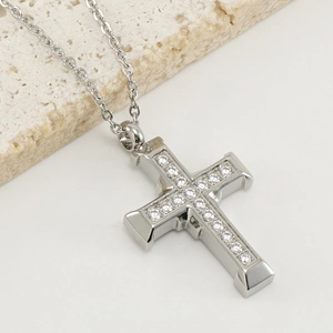 Minimalist silver cross necklace with sparkling cubic zirconia on a natural stone base