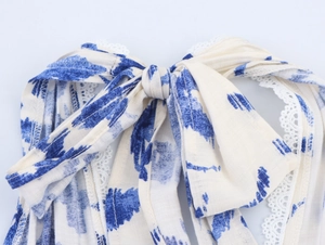 Détail de robe tie-dye bleue et blanche avec dentelle et cordon à nœud papillon