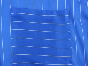 Gros plan détaillé des coutures sur la poche du pyjama à rayures bleu marine et tissu