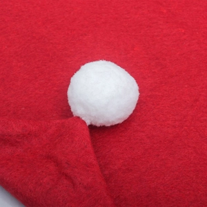 Detailed view of red felt fabric and white pom-pom decoration on a Christmas chair cover