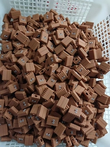 Massive collection of brown cartoon cookie cable protectors in a factory storage basket