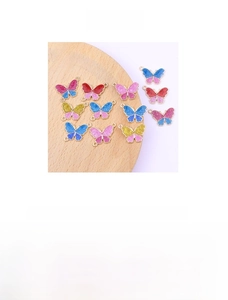 Macro detail of colorful butterfly alloy pendants with gold plating and glitter enamel finish