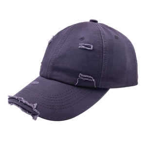 Detail showing distressed holes and frayed edges on purple vintage cotton baseball cap