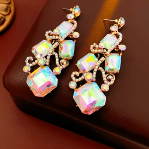 Macro detail of vintage square earrings with AB rhinestones on a brown leather surface