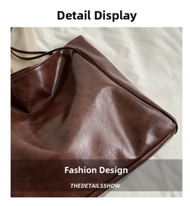 Detail of dark brown oil wax leather tote showing shiny texture and fine stitching