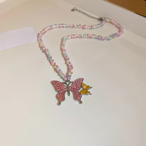 Detailed view of beaded necklace featuring pink and yellow butterflies and colored glass beads