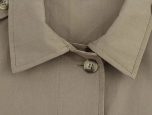 Dettaglio macro del tessuto twill kaki con bottone in tartaruga e cuciture di qualità