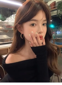 Close-up of stylish gold irregular hoop earrings worn by a model in a cozy cafe