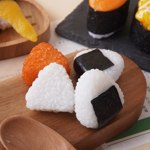 Realistic artificial triangular onigiri and assorted sushi models on wooden tray