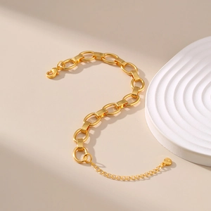 Close-up of a chunky 18K gold-plated chain bracelet with lobster clasp and heart charm