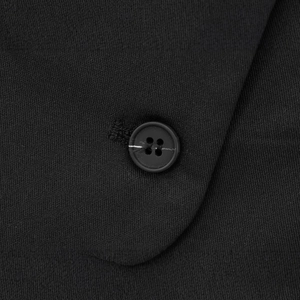 Close-up of a black quilted vest featuring a stand collar and matching 4-hole button detail