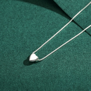 Minimalist s925 silver heart pendant necklace on a dark green textured background