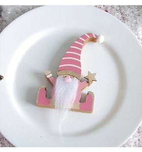 Detailed view of pink wooden gnome figurine with white beard and star on white plate